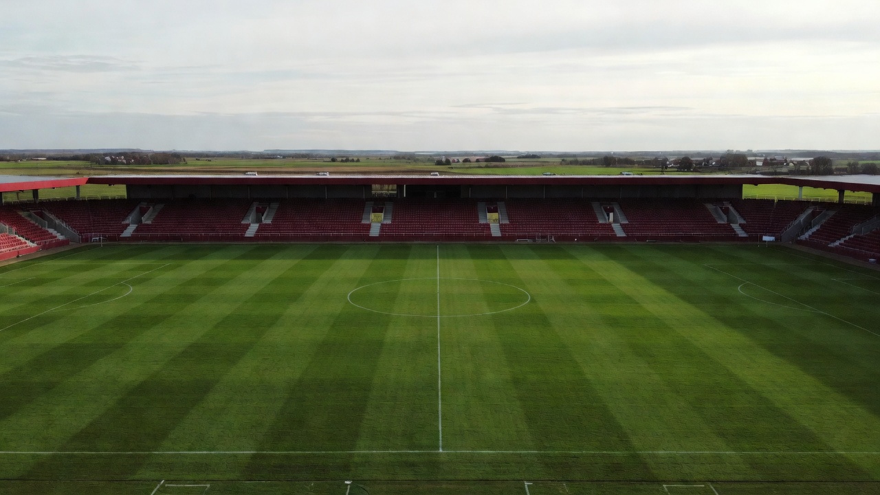 Football pitch and dark red grandstands in central Jutland